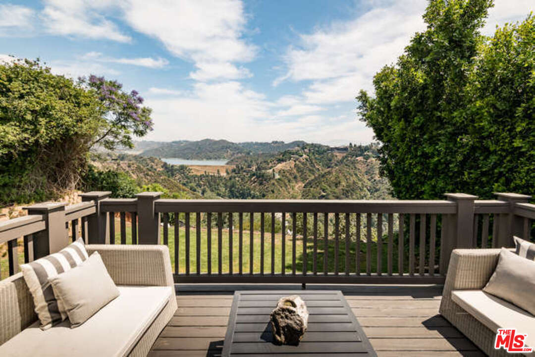 1374 Stradella Road Los Angeles, CA 90077 - Photo 27 of 47 a balcony with wooden floor table and chairs