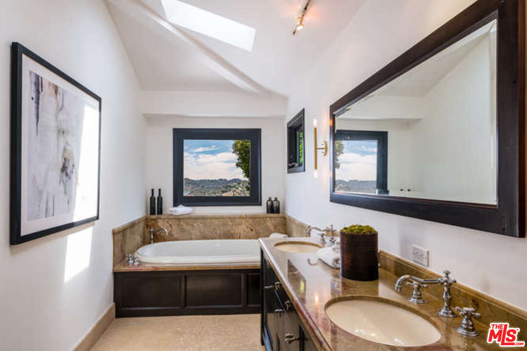 1374 Stradella Road Los Angeles, CA 90077 - Photo 30 of 47 a bathroom with a granite countertop tub a sink and a mirror