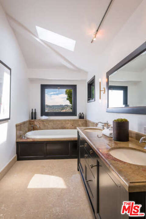 1374 Stradella Road Los Angeles, CA 90077 - Photo 32 of 47 a spacious bathroom with a granite countertop sink and a bathtub