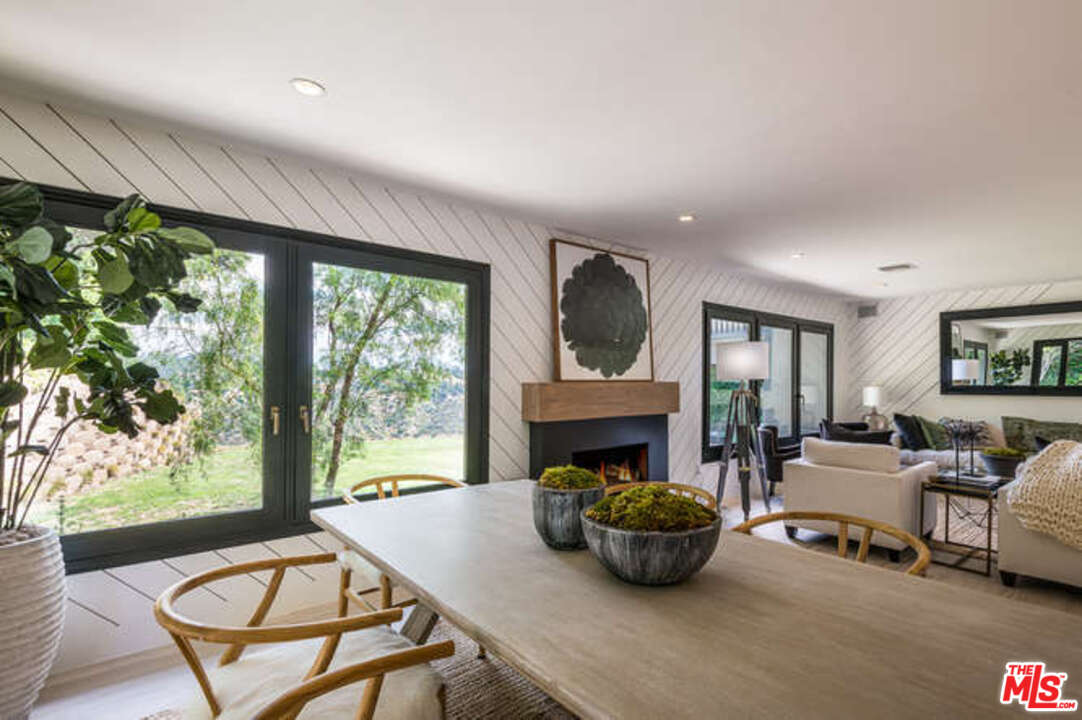1374 Stradella Road Los Angeles, CA 90077 - Photo 10 of 47 a living room with furniture a fireplace and a floor to ceiling window