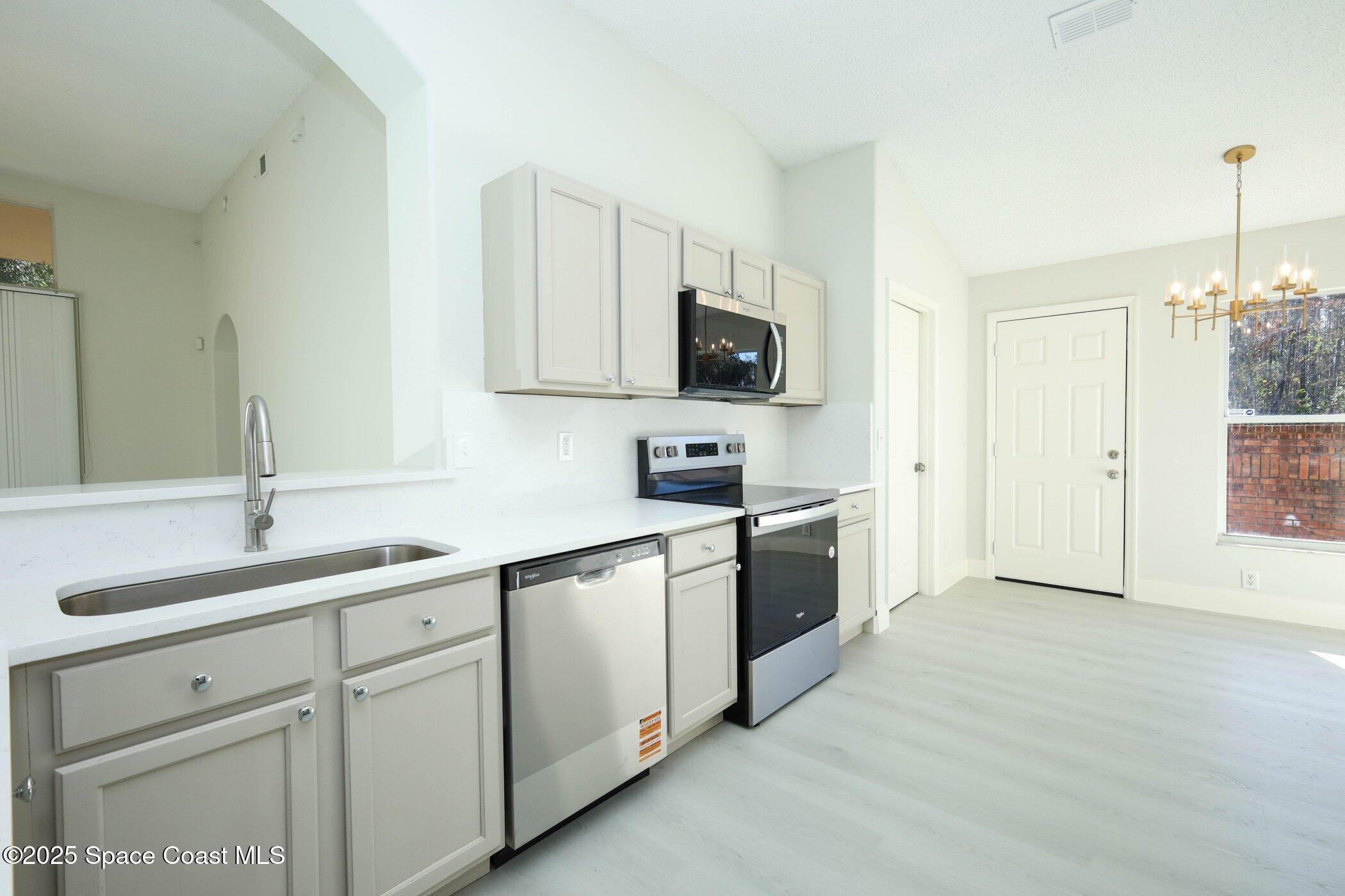 3700 Becontree Place Oviedo, FL 32765 - Photo 11 of 39 a kitchen with white cabinets sink and stove