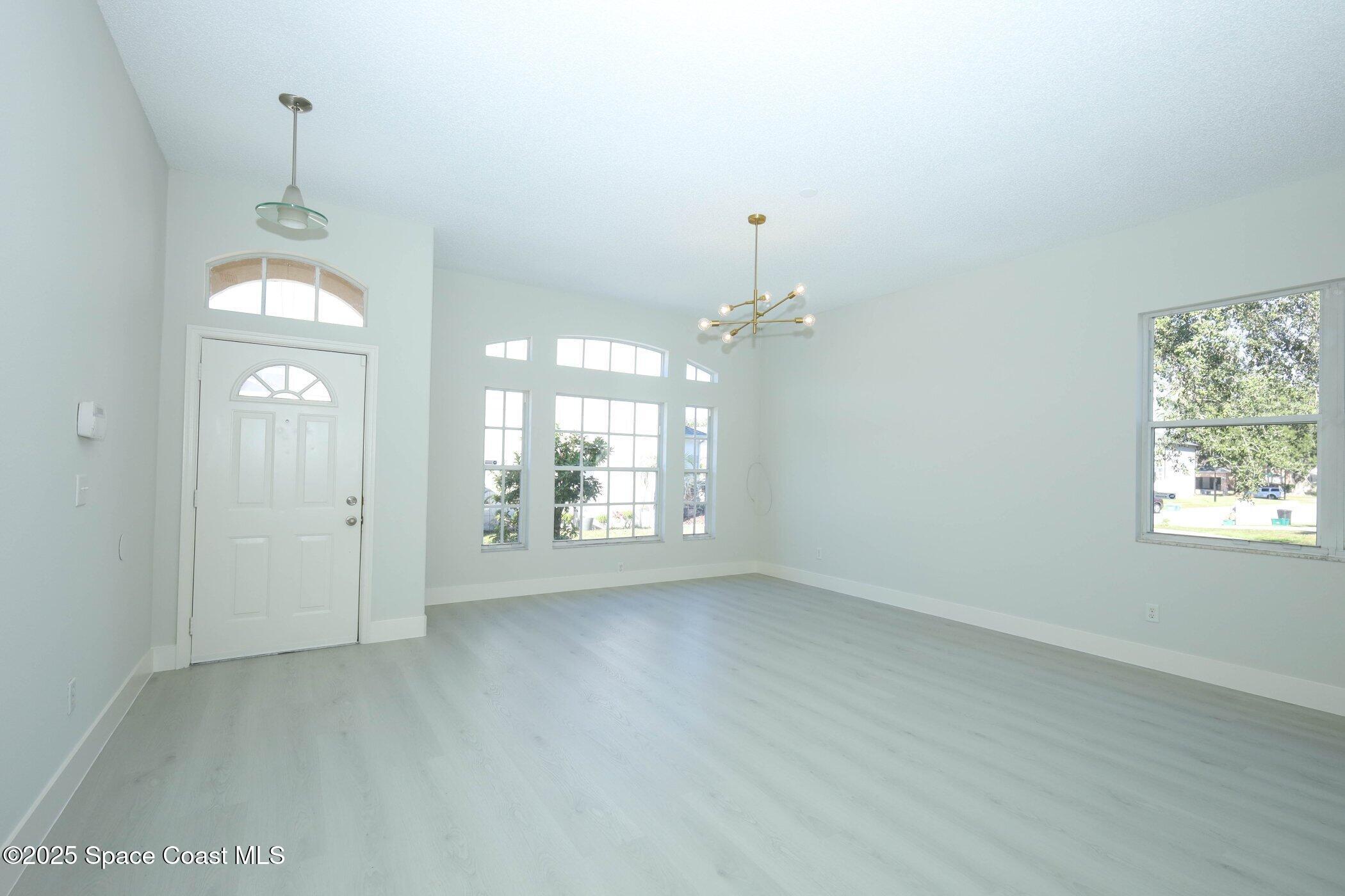 3700 Becontree Place Oviedo, FL 32765 - Photo 4 of 39 en empty room with windows and ceiling fan