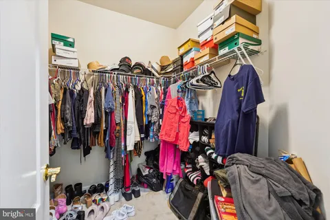 a view of walk in closet with clothes