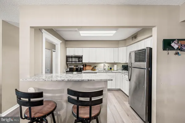 a kitchen with stainless steel appliances granite countertop a refrigerator and a stove top oven
