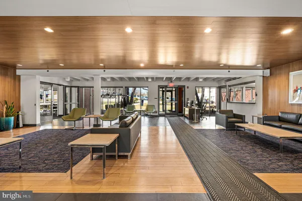 a living room with furniture a large window and wooden floor