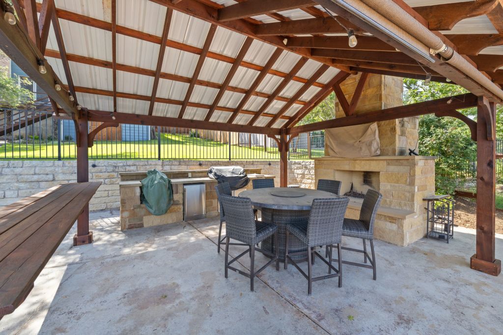 10800 Beach Road Leander, TX 78641 - Photo 32 of 39 An inviting outdoor living space features a covered patio with a built-in kitchen, fireplace, and ample room for entertaining.