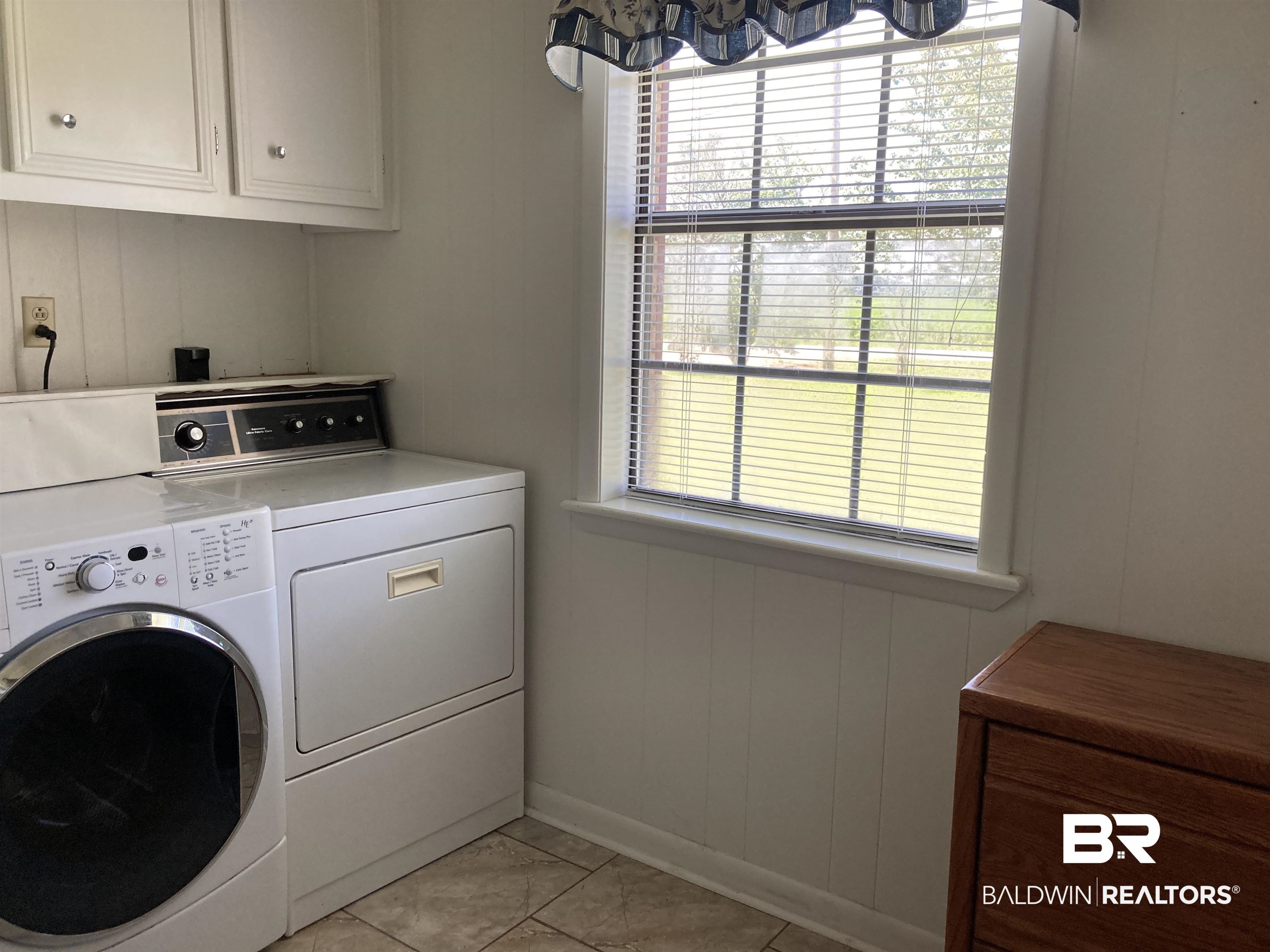 6151 Meadows Road Walnut Hill, FL 32568 - Photo 17 of 29 Laundry room featuring light tile patterned flooring, cabinets, independent washer and dryer, and a wealth of natural light