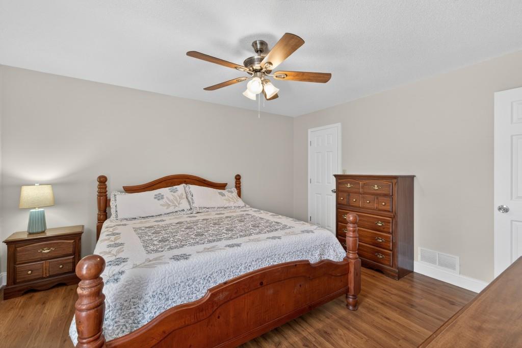 335 Ranger Way Braselton, GA 30517 - Photo 24 of 63 a bedroom with a bed and dresser with wooden floor