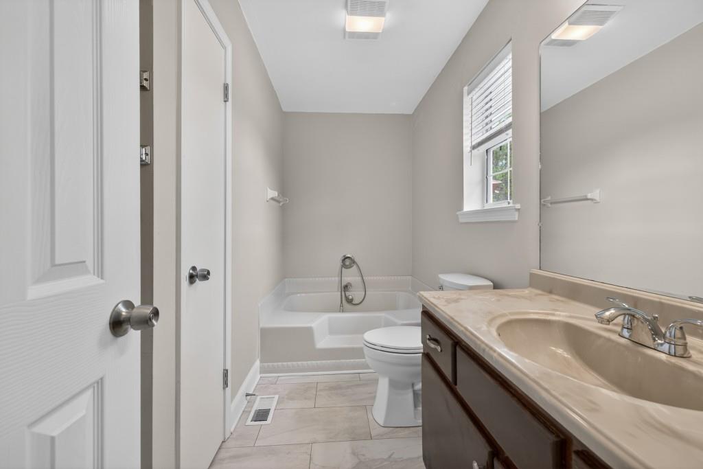 335 Ranger Way Braselton, GA 30517 - Photo 27 of 63 a bathroom with a granite countertop sink and a bathtub