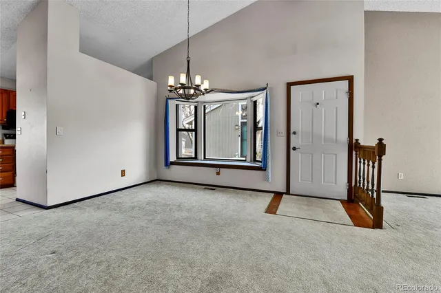 an empty room with a fireplace and windows