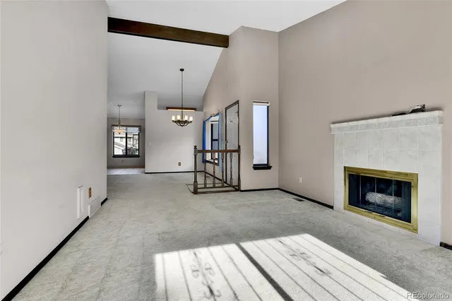 a view of a livingroom with a chandelier fan and windows