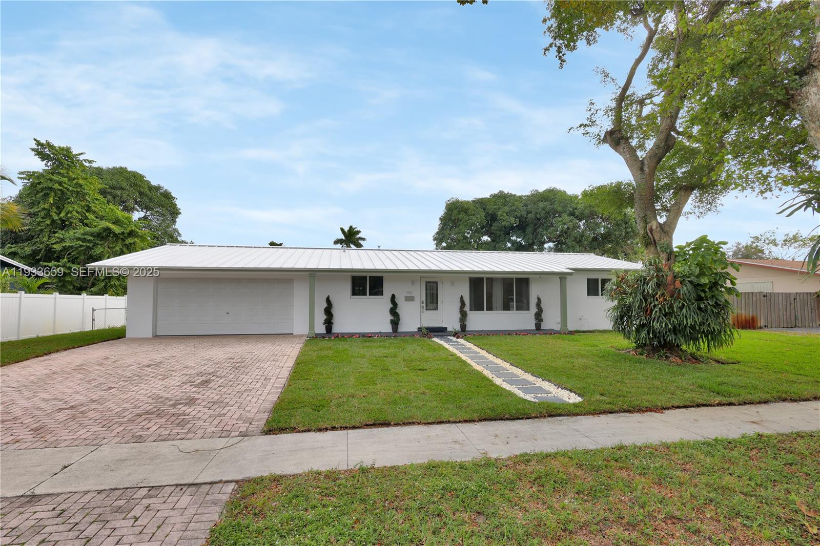142 Southwest 53rd Avenue Plantation, FL 33317 - Photo 2 of 30 a front view of a house with a yard and potted plants