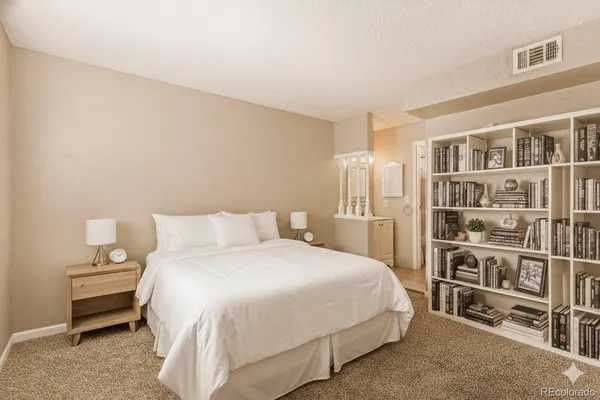 a bedroom with a bed and a book shelf