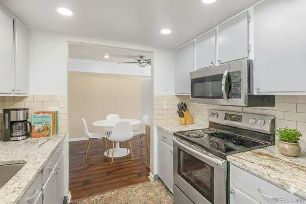 a kitchen with stainless steel appliances kitchen island granite countertop a stove a sink and a microwave
