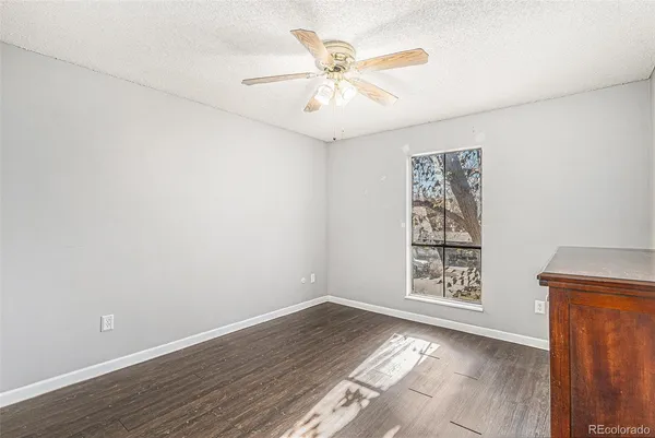 an empty room with windows and ceiling fan