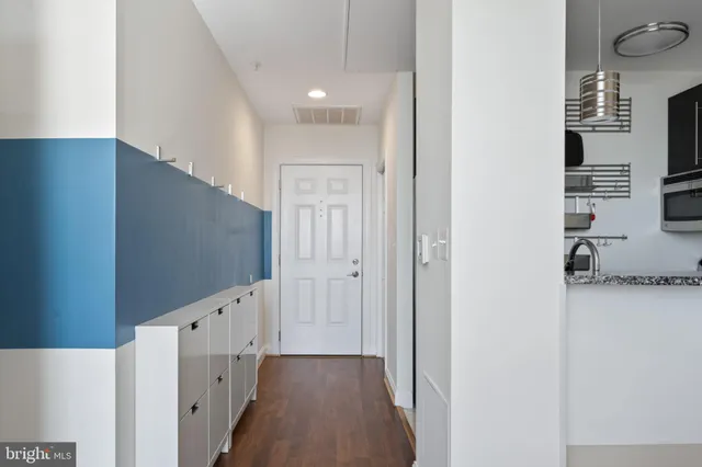 a view of a hallway with wooden floor and a living room