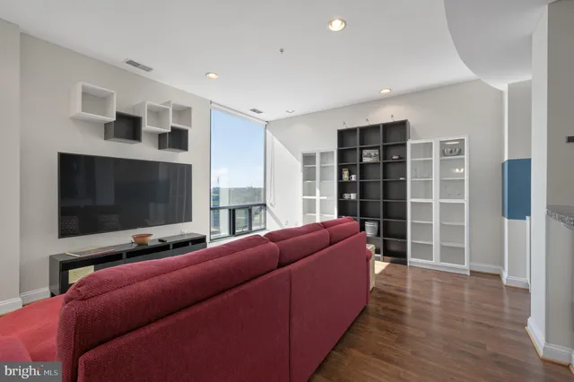 a living room with furniture and a wooden floor