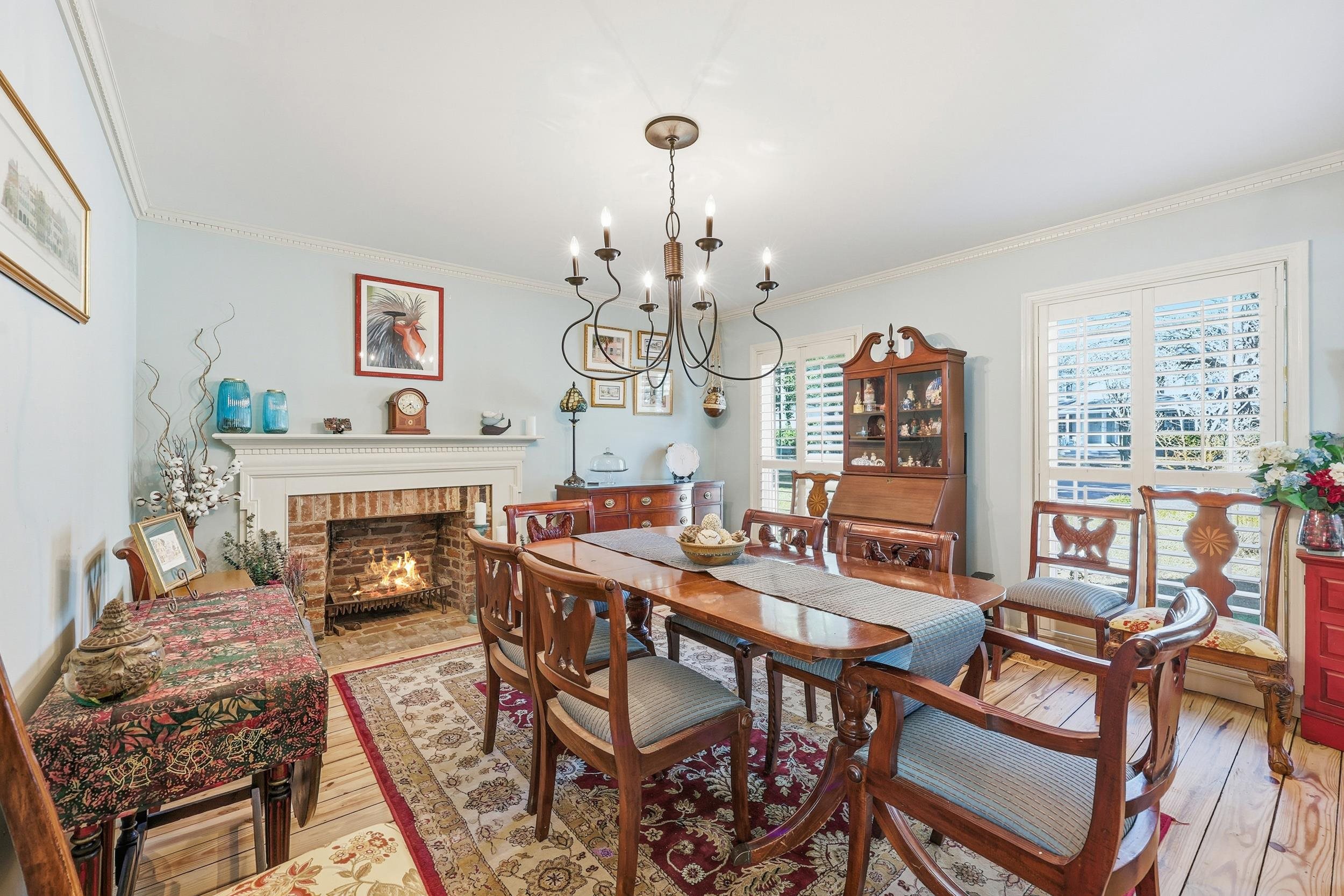 709 Mt Gilead Road Murrells Inlet, SC 29576 - Photo 14 of 38 Dining space featuring crown molding, a brick fireplace, hardwood / wood-style floors, and a chandelier