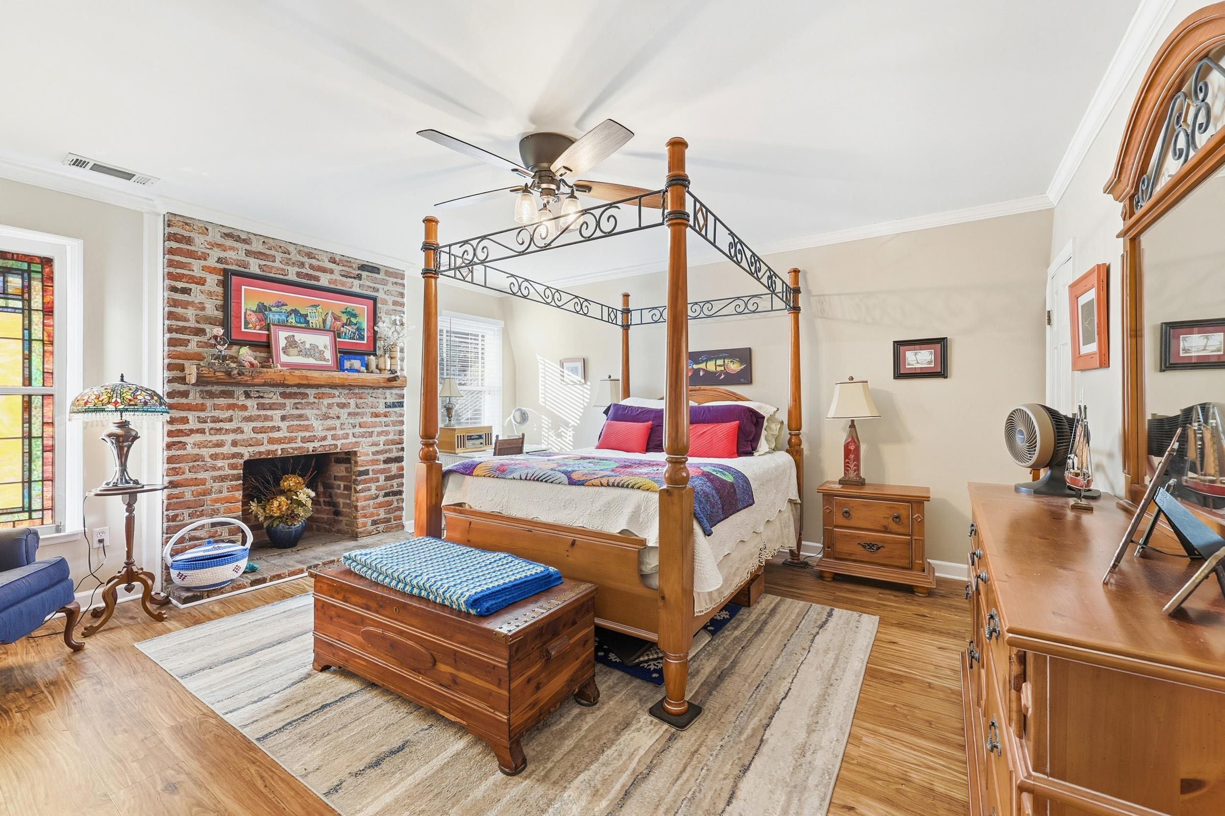 709 Mt Gilead Road Murrells Inlet, SC 29576 - Photo 24 of 38 Bedroom featuring ornamental molding, light wood-style floors, a ceiling fan, and a brick fireplace