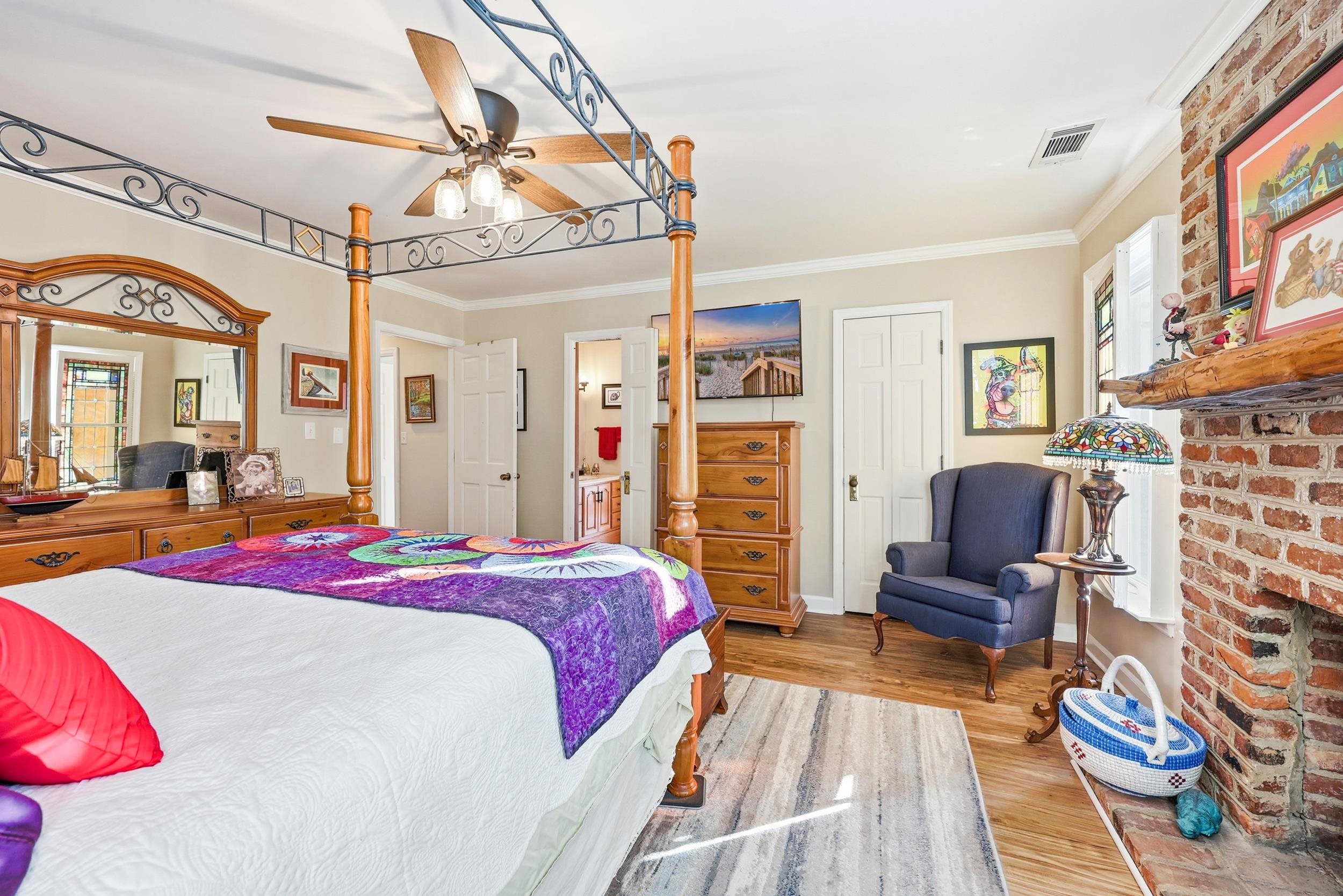 709 Mt Gilead Road Murrells Inlet, SC 29576 - Photo 25 of 38 Bedroom with a brick fireplace, wood finished floors, ornamental molding, connected bathroom, and ceiling fan
