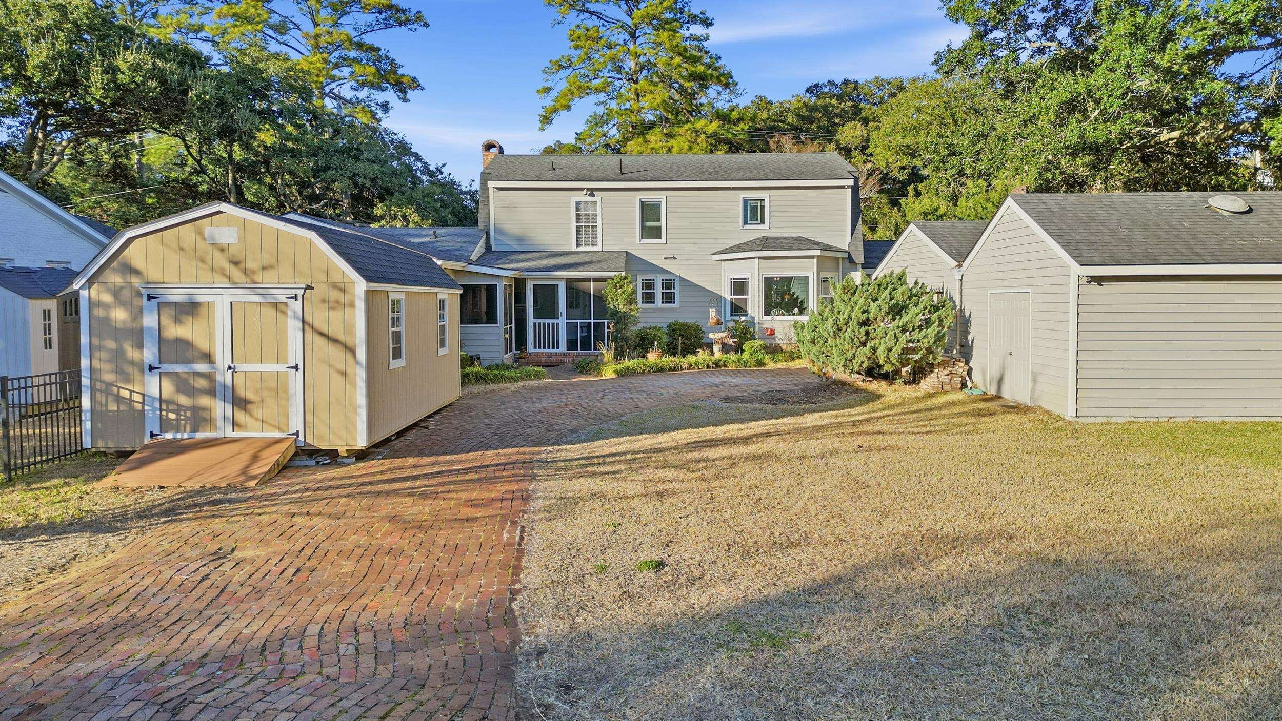 709 Mt Gilead Road Murrells Inlet, SC 29576 - Photo 34 of 38 View of front of home featuring a storage unit, a sunroom, a chimney, and a front yard