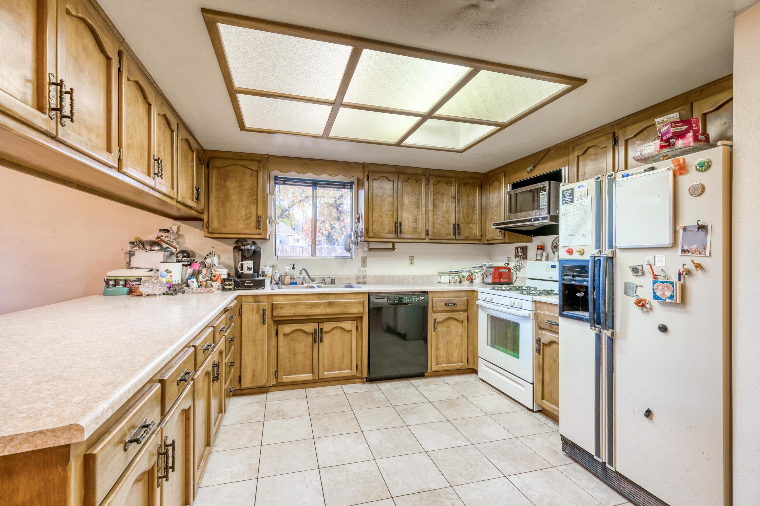 2274 Jessica Way Redding, CA 96002 - Photo 4 of 18 a kitchen with stainless steel appliances granite countertop a refrigerator a sink dishwasher a stove with wooden cabinets and floors