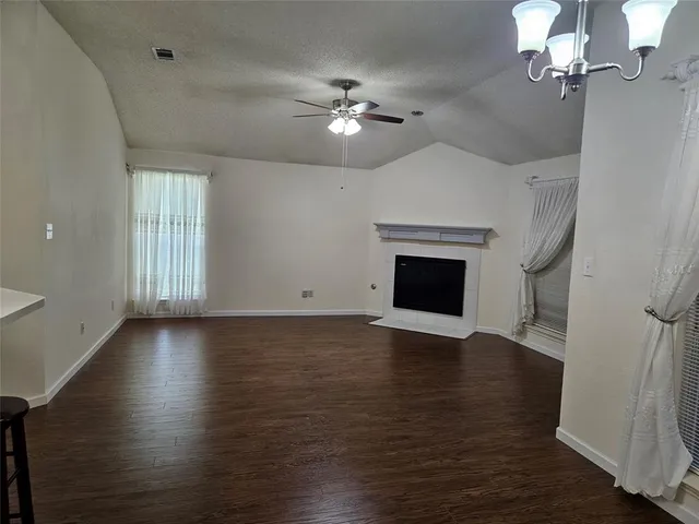 wooden floor in an empty room with a chandelier fan