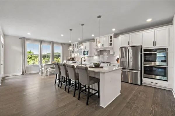 a kitchen with a table chairs refrigerator and microwave