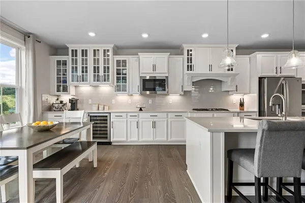 a kitchen with stainless steel appliances kitchen island granite countertop a stove a sink and a refrigerator