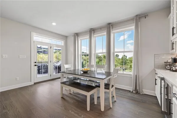 a dining room with wooden floor and a floor to ceiling window
