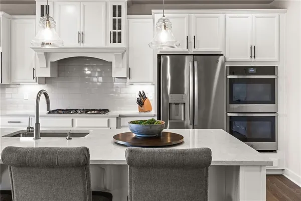 a kitchen with stainless steel appliances a sink and a refrigerator