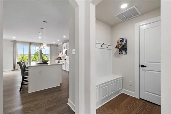 a kitchen with white cabinets and wooden floor