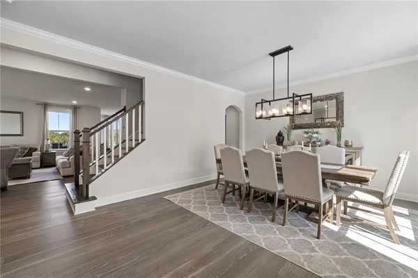 a view of a dining room and livingroom with furniture wooden floor a chandelier