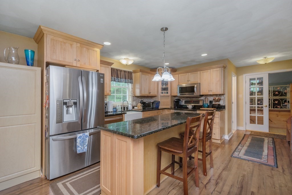 132 Fowler Road Northbridge, MA 01534 - Photo 12 of 42 a kitchen with stainless steel appliances granite countertop a refrigerator a oven a sink a stove and white cabinets with wooden floor