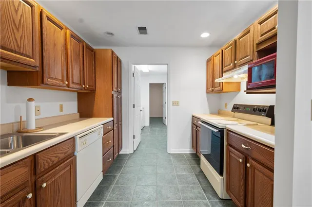 a kitchen with a refrigerator sink and cabinets