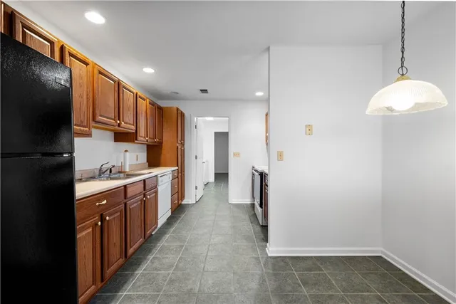 a kitchen with granite countertop a refrigerator and a sink