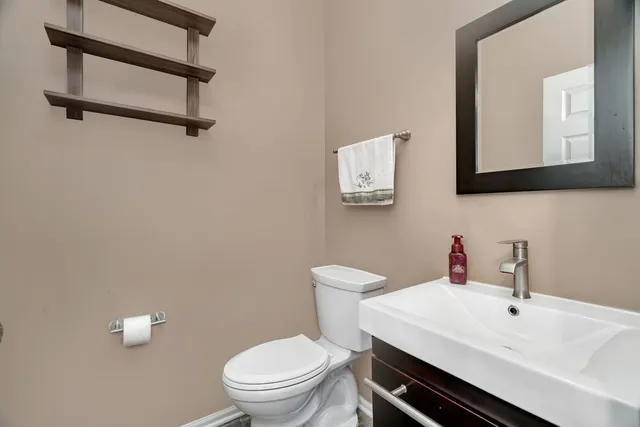 a bathroom with a toilet a sink and mirror