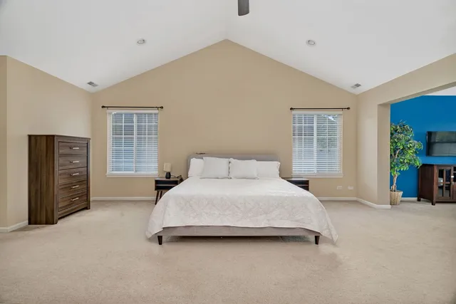 a spacious bedroom with a bed and a cabinets