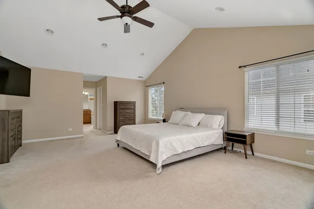 a spacious bedroom with a bed and a flat screen tv