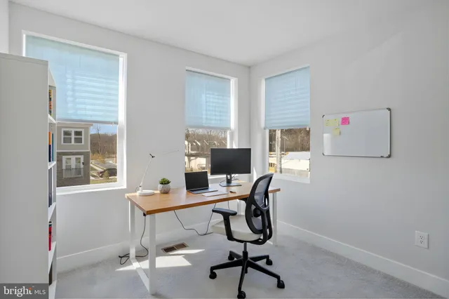 a view of a workspace with furniture and a window