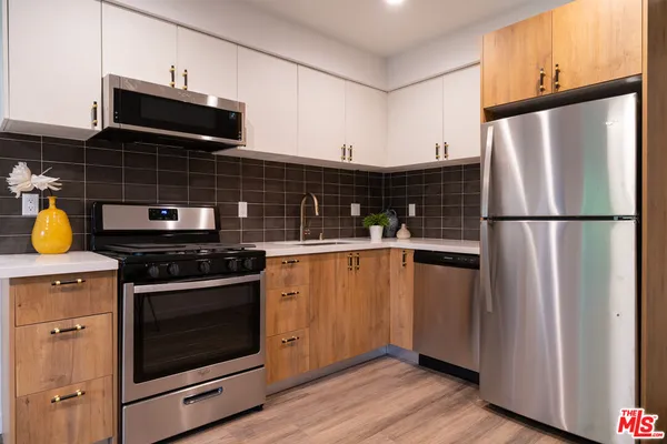 a kitchen with appliances a counter space and cabinets