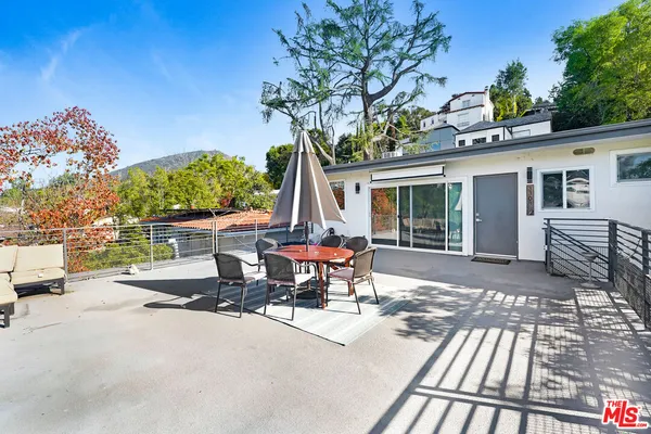 a view of a patio with a table and chairs and potted plants