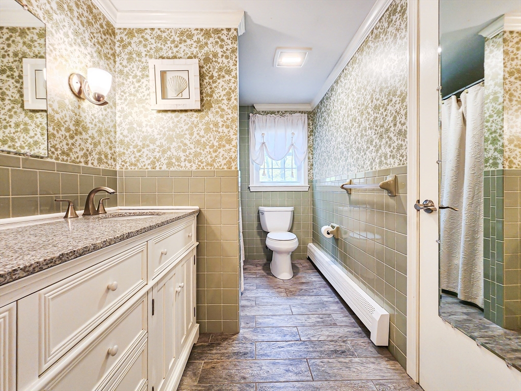 29 Sullivan Road Yarmouth, MA 02673 - Photo 14 of 42 a spacious bathroom with a granite countertop sink and a large mirror