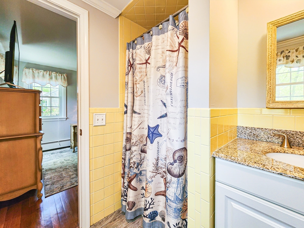 29 Sullivan Road Yarmouth, MA 02673 - Photo 19 of 42 a bathroom with a granite countertop shower a mirror and a sink