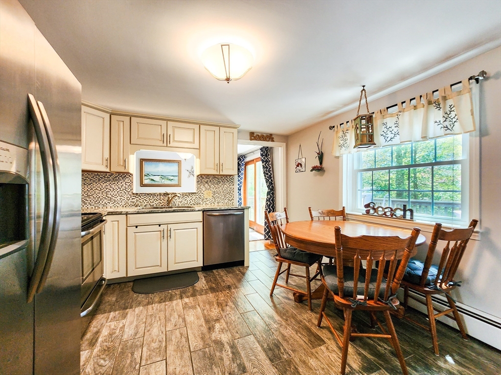29 Sullivan Road Yarmouth, MA 02673 - Photo 6 of 42 a kitchen with a table chairs stove refrigerator and cabinets