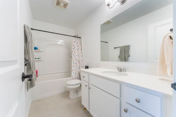 a bathroom with a double vanity sink toilet mirror and shower