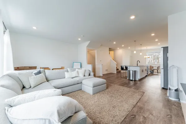 a living room with furniture and a view of kitchen