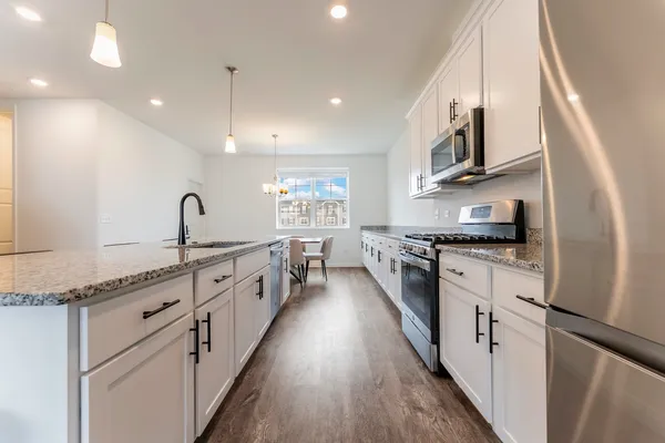 a large kitchen with stainless steel appliances granite countertop a lot of counter space