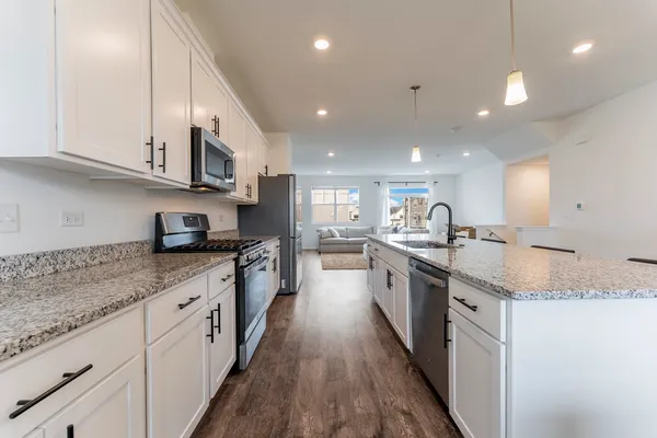 a large kitchen with stainless steel appliances granite countertop a lot of counter space and a sink