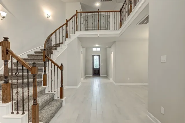 a view of staircase with lots of frames on wall and windows
